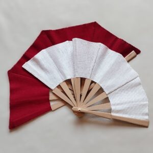 Abanico de lino natural 100% artesanal de diseño minimalista con país de lino 100% natural rojo y blanco, montado sobre varillas de madera de abedul clara con remache dorado central y textura textil rústica visible.
